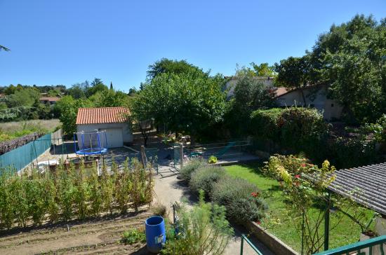 Vue sur jardin potager, aire de jeux.